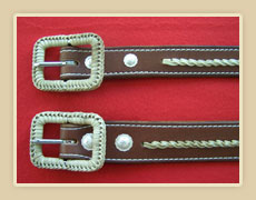 Matching pair of belts with rawhide accents and rawhide braided buckles.