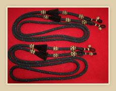 Braided nylon roping reins with horsehair tassels and rawhide knots and rawhide connectors.